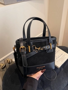 Retro black bucket bag in suede and leather mix with gold metal accents and strap