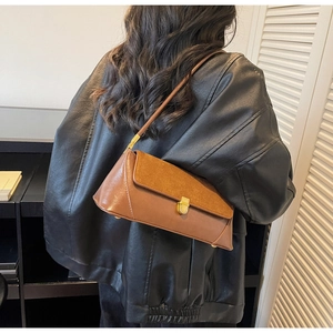 Detail of vintage brown baguette bag featuring gold square swivel lock and mixed leather
