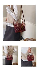 Detailed view of burgundy quilted box bag with silk scarf handle and gold zippers