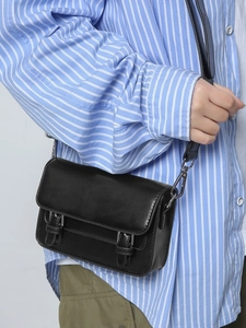 Black leather crossbody bag with silver hardware buckles and classic flap closure design