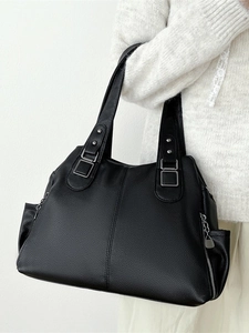 Large black textured leather tote bag shown on model for stylish daily commuting use