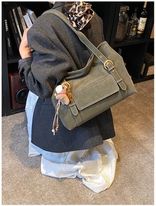 Détail du sac cabas en daim vert armée avec surpiqûres blanches et charme de cheval
