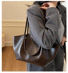 Détail de la texture d'un sac cabas marron rétro et coutures sur un grand sac à bandoulière