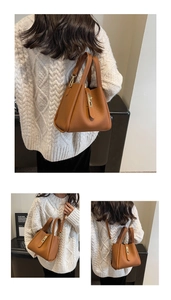 Detail of brown litchi pattern bucket bag with golden hardware and adjustable strap