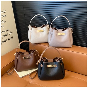 Close-up of four colored bucket bags showing pebble leather texture and gold metal locks