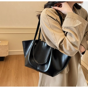 Détail du grand sac cabas noir en cuir ciré brillant avec surpiqûres et bandoulière