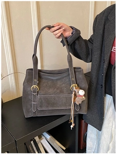 Détail du sac cabas en daim gris foncé avec surpiqûres blanches et charme de cheval