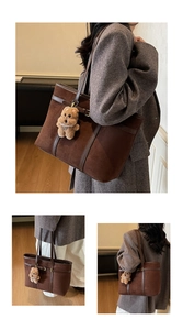 Detail of vintage brown suede tote bag with plush bear charm and leather handle