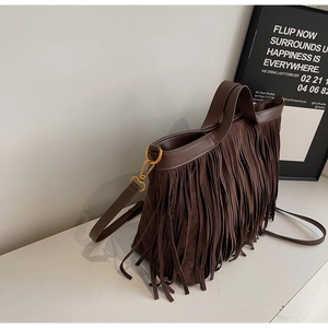Vue détaillée du cabas en daim marron foncé avec de longues franges et des crochets dorés