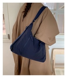 Sac fourre-tout en nylon bleu marine porté à l'épaule par un mannequin de style