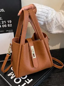 Classic tan pebbled leather bucket bag with gold lock and adjustable crossbody strap