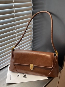 Brown retro PU leather baguette bag with gold metal buckle shown in cinematic lighting