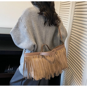 Détail d'un sac bohème en daim kaki avec de longues franges et une boucle métallique