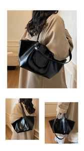 Détail du grand sac cabas noir avec doubles anses et texture en cuir brillant