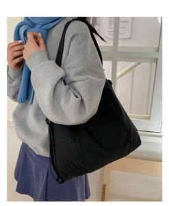 Détail de la poche latérale zippée invisible sur un grand sac cabas noir en nylon