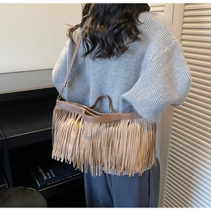 Détail d'un sac cabas en daim kaki avec franges, vue de dos porté par un modèle