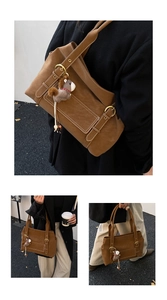 Détail d'un sac cabas en cuir marron avec coutures blanches et breloque poney peluche