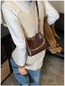 Braune Umhängetasche aus Kunstleder am Modell für einen stilvollen Pendler-Look
