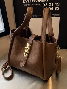 Brown lychee grain leather bucket bag with gold lock and adjustable shoulder strap