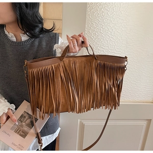 Détail d'un sac cabas marron à franges en daim avec bandoulière réglable chic