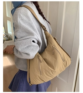 Sac fourre-tout en nylon kaki sur mannequin montrant le design spacieux et poches zippées