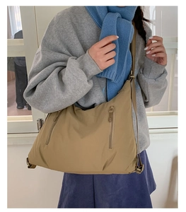 Détail du sac hobo en nylon kaki montrant la grande capacité et les poches zippées avant