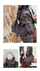 Detail of dark brown hobo shoulder bag with long side tassels and silver rivets