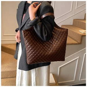 Detail of dark brown quilted tote bag showing high-quality PU leather and glossy finish