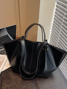 Grand sac cabas noir en cuir 2025 avec longues anses dans un décor de bureau à domicile