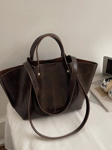 Grand sac cabas minimaliste en cuir ciré marron avec anses sur un bureau blanc