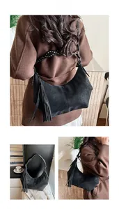 Detail of black PU leather hobo bag with fringe decor and silver rivet shoulder strap
