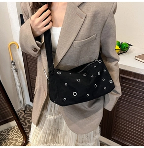 Photo de style d'un sac cabas noir en toile avec œillets porté avec un blazer kaki