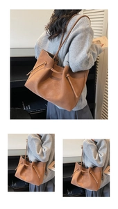 Detail of a brown suede tote bag featuring a decorative drawstring knot and slender strap