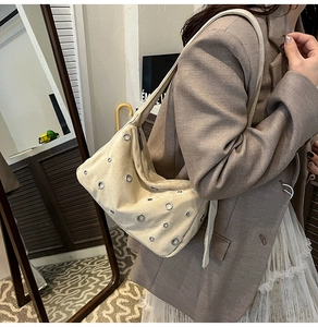 Détail du sac beige avec œillets métalliques et texture mate de style vintage