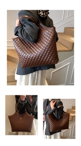 Macro shot of large quilted tote bag with brown leather texture and gold logo detail