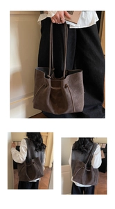 Detail of dark brown faux suede tote bag featuring drawstring knot and slim shoulder straps