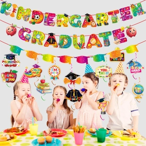 Kids celebrating with Kindergarten Graduate rainbow banner and party swirl decorations