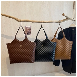 Detailed display of large quilted tote bags in brown, black, and caramel faux leather