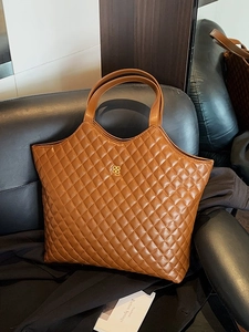 Brown quilted leather tote bag with gold clover logo and double handles for work