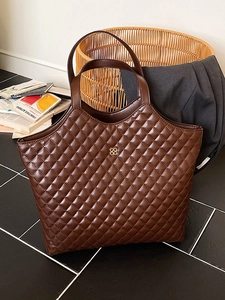 Large brown quilted tote bag with golden clover logo for stylish daily commuting