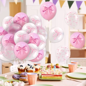 Pink and white latex balloons with bow patterns on a festive party dessert table