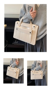 Dettaglio della borsa tote crema minimalista con tasca frontale e bottoni neri