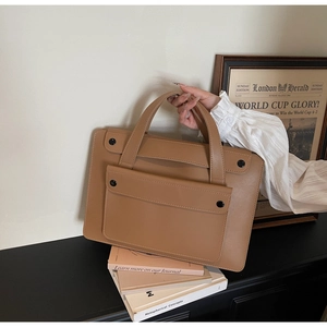 Dettaglio della borsa porta PC color cammello con tasca magnetica su sfondo beige