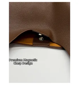 Detail of dark brown lychee leather tote with silver magnetic closure and yellow suede lining