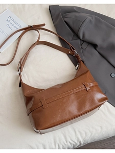 Détail du sac hobo en cuir huilé marron foncé avec bandoulière réglable et ferrures argent