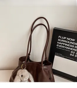 Détail du grand sac cabas en cuir marron avec fines bandoulières et breloque lapin