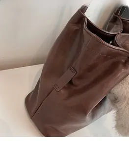 Gros plan d'un cabas vintage marron foncé avec texture cuir ciré et coutures renforcées