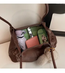 Vue détaillée du sac cabas marron montrant sa grande capacité pour ordinateur et effets