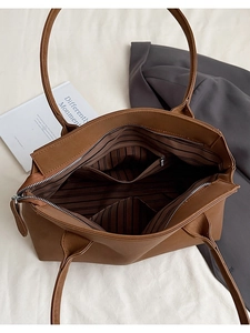 Vue de dessus du sac cabas marron montrant la doublure rayée et la poche zippée interne