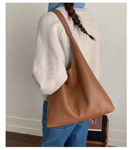 Detailed view of the large caramel brown leather hobo bag worn over the shoulder